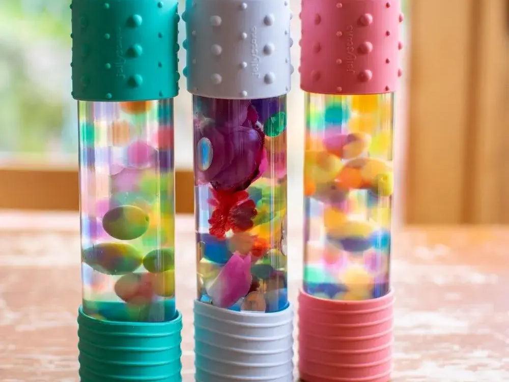 Três brinquedos sensoriais coloridos com bolhas e peças brilhantes, perfeitos para estimular os sentidos das crianças.