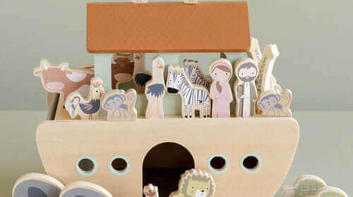 Brinquedo de madeira em forma de barco com figuras de animais e personagens, ideal para crianças de 2 anos.