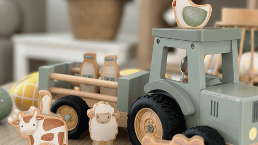 Colorful wooden farm toys including a tractor, animals, and milk bottles on a playful surface.