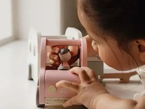 Criança brincando com um brinquedo educativo rosa e uma figura, estimulando o desenvolvimento e a criatividade.