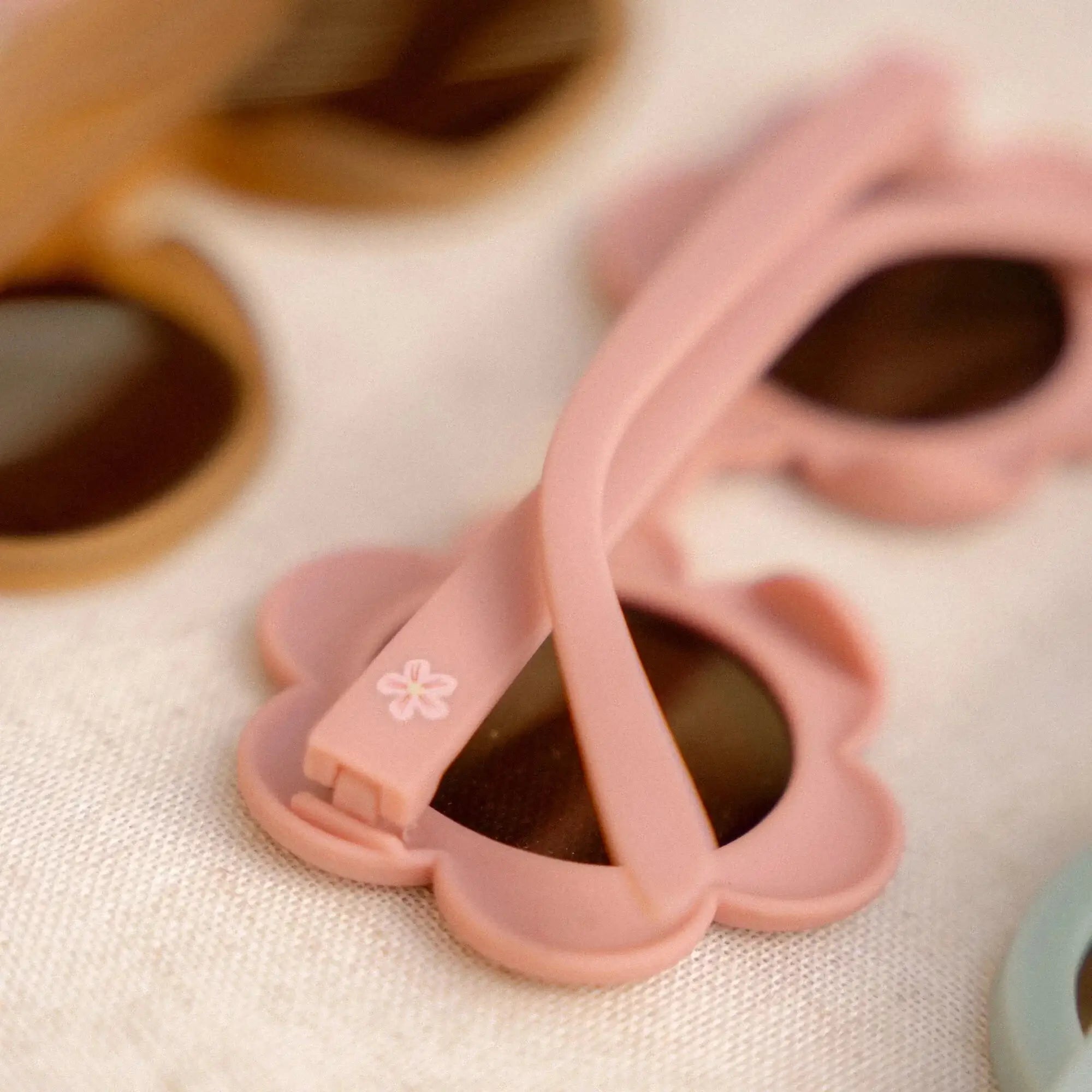 Óculos de sol de criança em forma de flor pink, com lentes escuras, perfeitos para proteção solar e estilo.