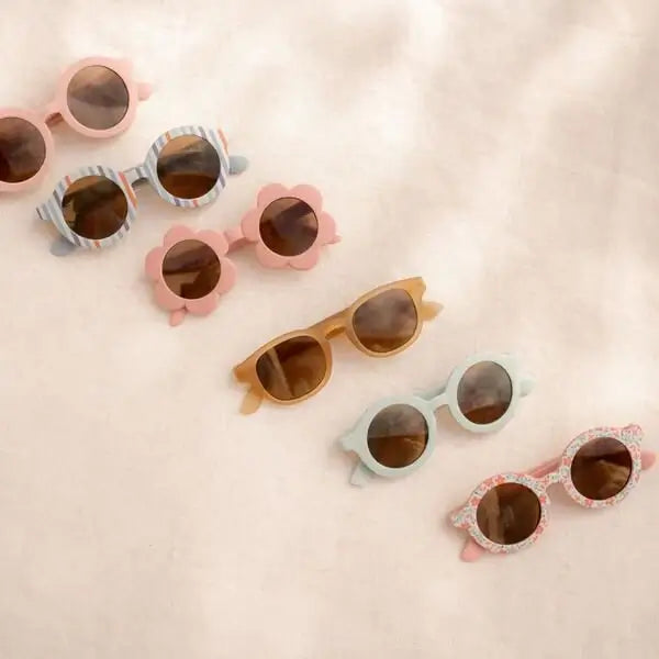 Óculos de sol de criança em estilo redondo com flores, em tons pastel, perfeitos para proteção UV e estilo no verão.