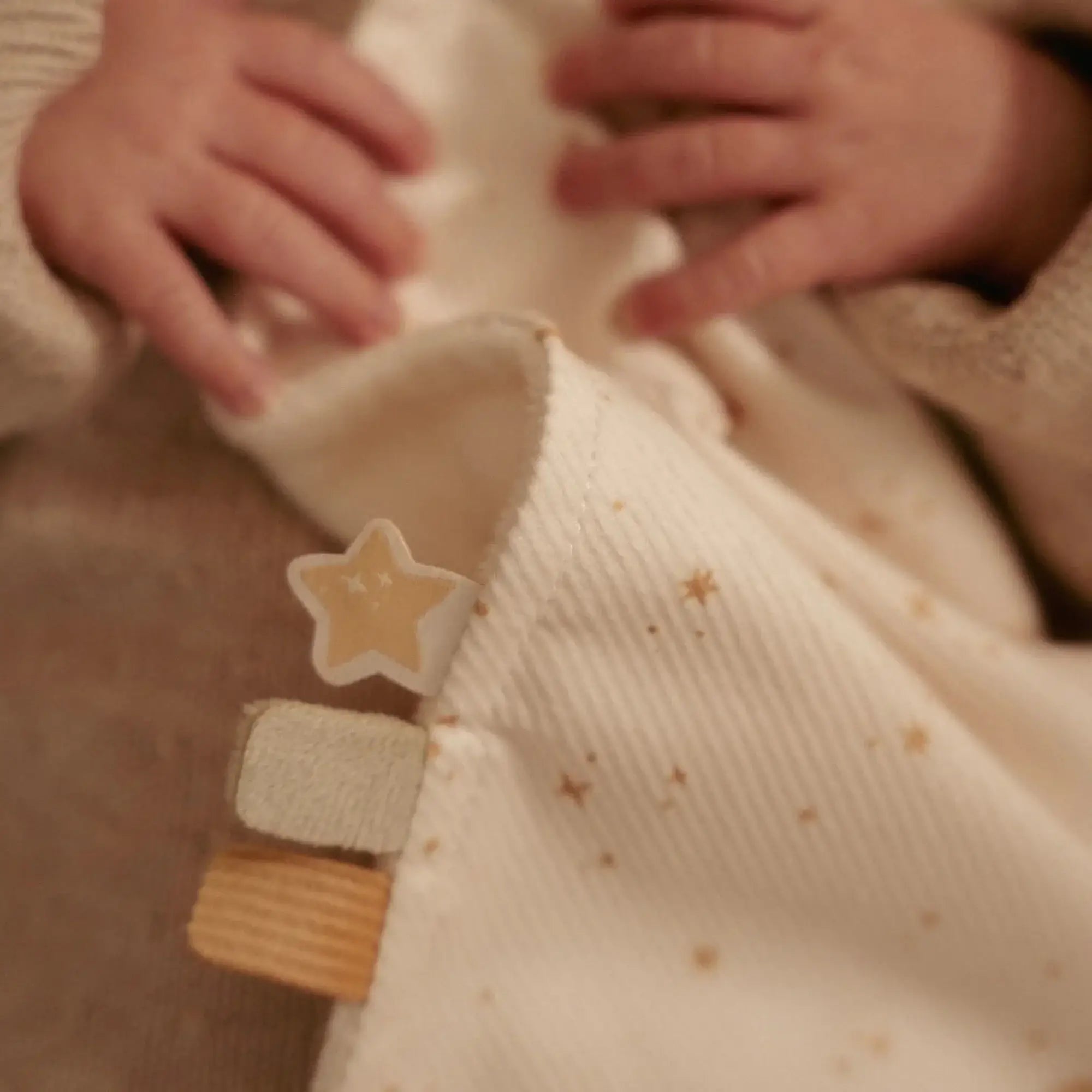 Bebé segurando o Doudou com Anel de Dentição - Newborn Naturals da Little Dutch, destacando a suavidade e conforto.