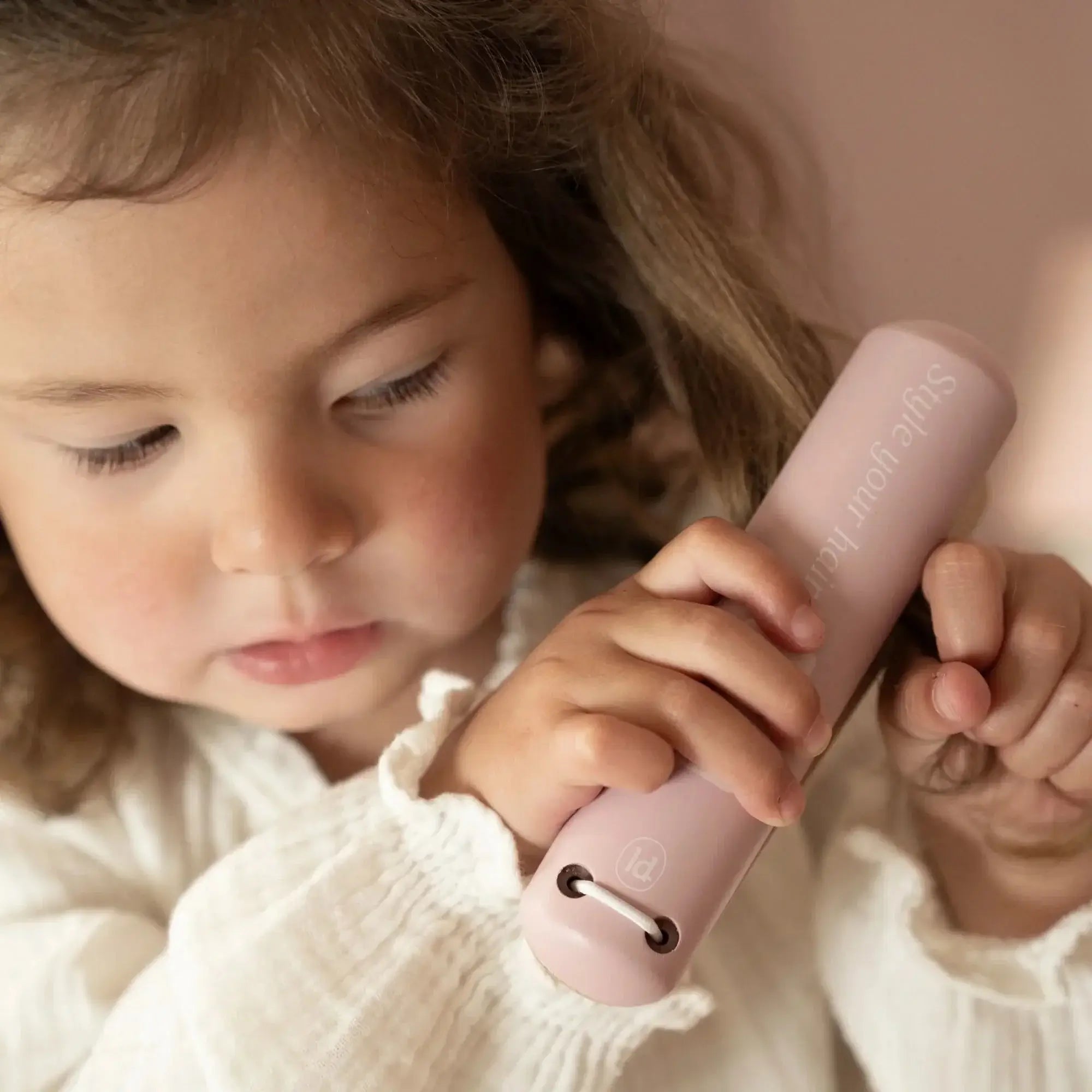 Criança brincando com o Conjunto de Cabeleireiro Little Dutch, segurando um secador de cabelo rosa.