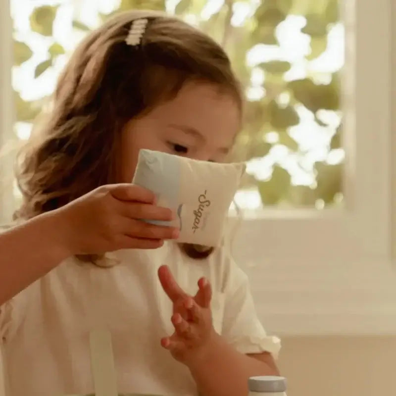 Menina usando o Conjunto de Pasteleiro Little Dutch com taça e ingredientes para bolachas.