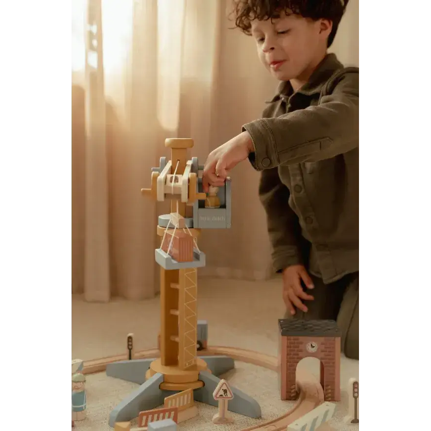 Criança brincando com Pista com Grua de Construção - Little Dutch, movimentando a grua e acessórios.