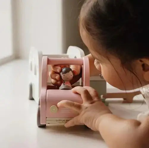 Criança brincando com um brinquedo educativo rosa e uma figura, estimulando o desenvolvimento e a criatividade.