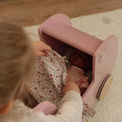 Carrinho para Bonecas Rosa com acessórios - Little Dutch, criança cuidando da boneca com cobertor floral.