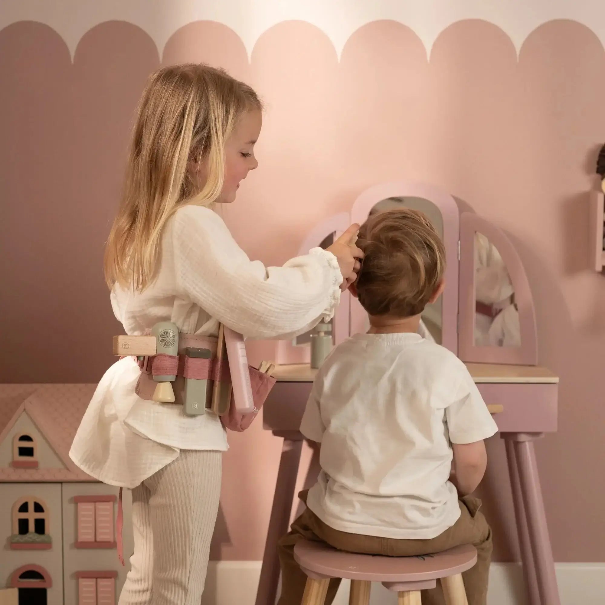 Criança brincando com o Conjunto de Cabeleireiro Little Dutch em um espelho, com acessórios de beleza.