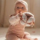 Baby exploring the Little Dutch Fairy Garden sensory ball with soft textures and vibrant colors.