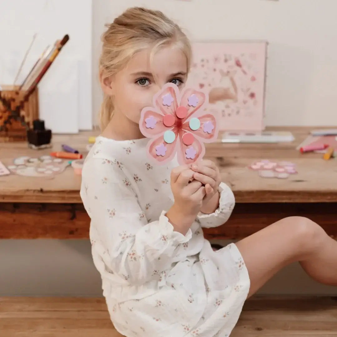 Girl holding a colorful flower craft made with the Little Dutch Fairy Garden kit, promoting creativity and fun.