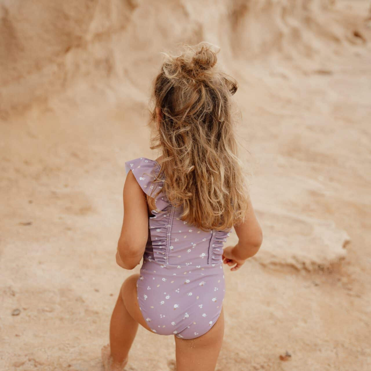 Menina usando fato de banho sem mangas mauve com alças da Little Dutch na praia.