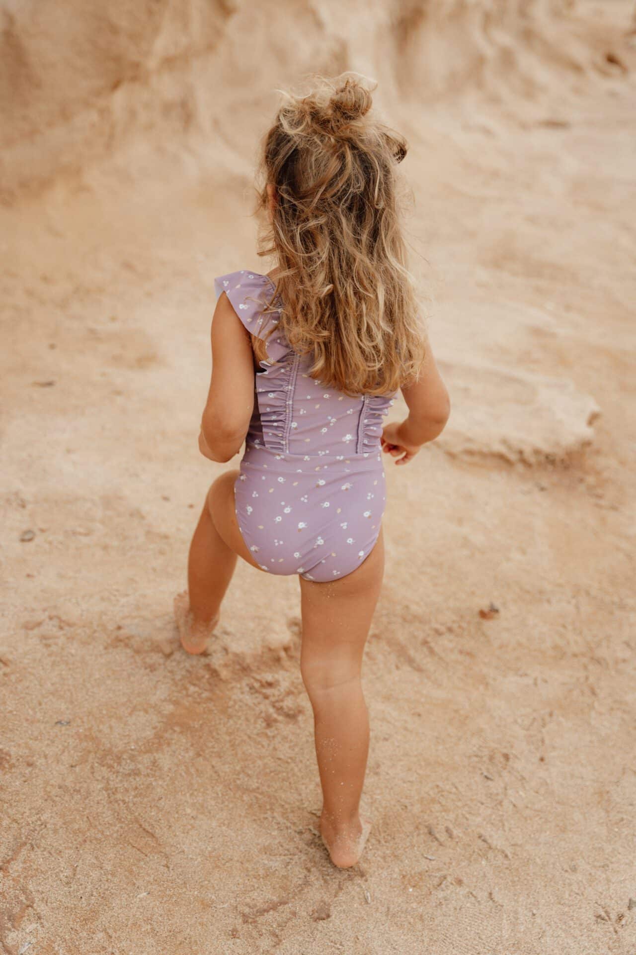 Menina usando fato de banho sem mangas mauve com alças da Little Dutch na praia.