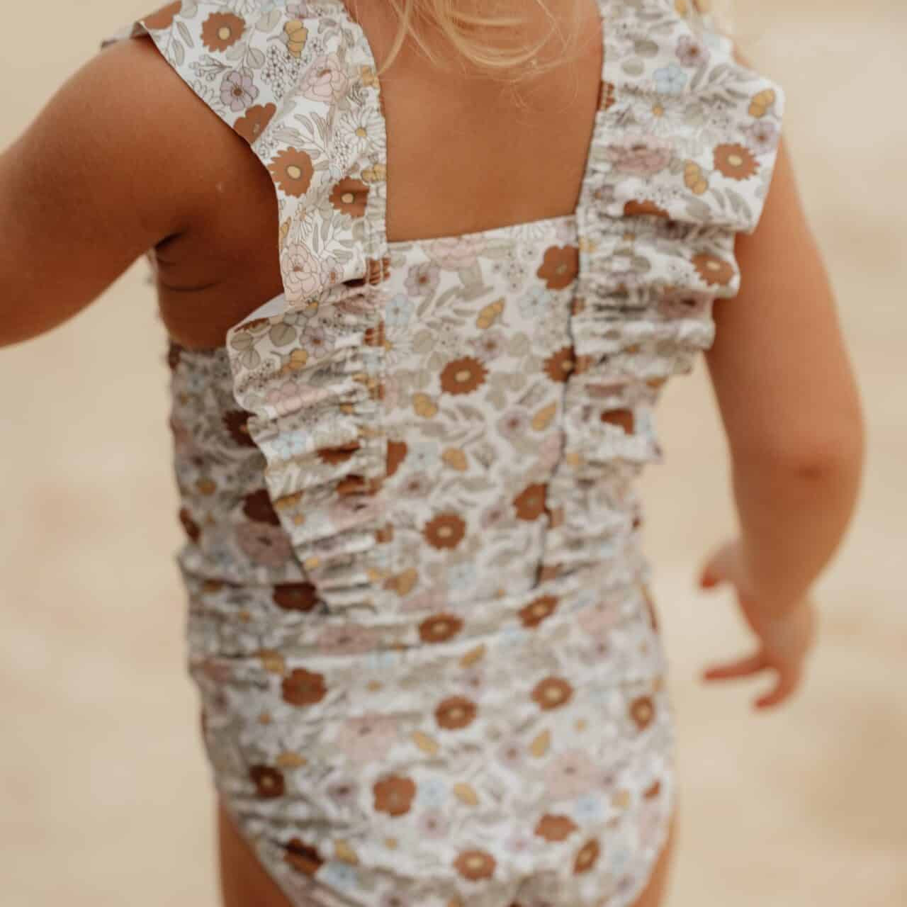 Child wearing a Little Dutch vintage floral ruffled swimsuit made from recycled polyester, perfect for swimming and outdoor play.