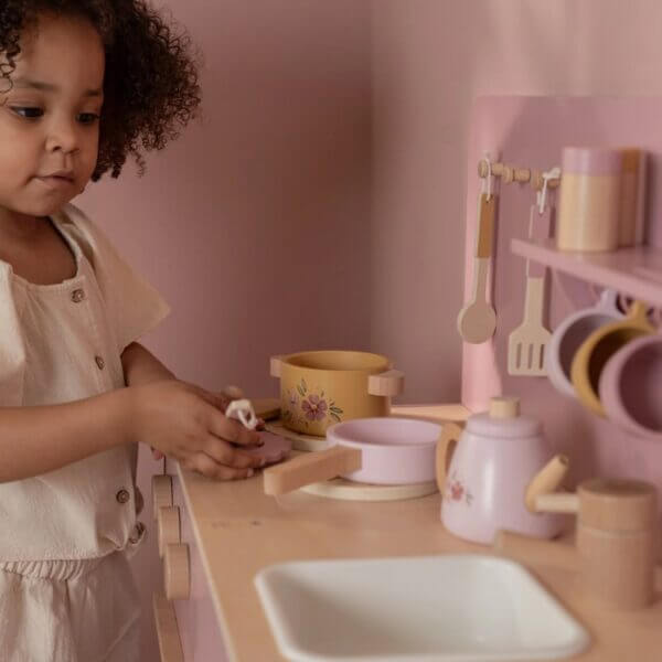 Criança brincando na Cozinha Rosa - Little Dutch, com panelas e utensílios de madeira e detalhes encantadores.