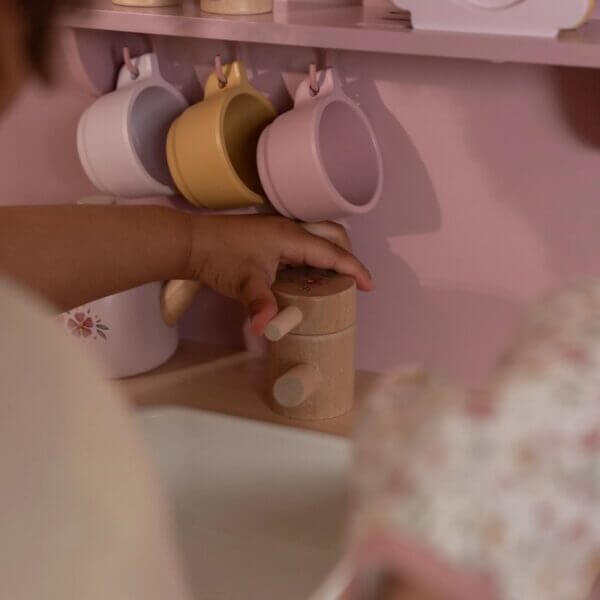 Criança brincando com a Cozinha Rosa - Little Dutch, mostrando acessórios coloridos e utensílios em madeira.