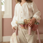 Conjunto de Cabeleireiro Little Dutch com criança usando bolsa de cintura e acessórios de cabeleireiro.