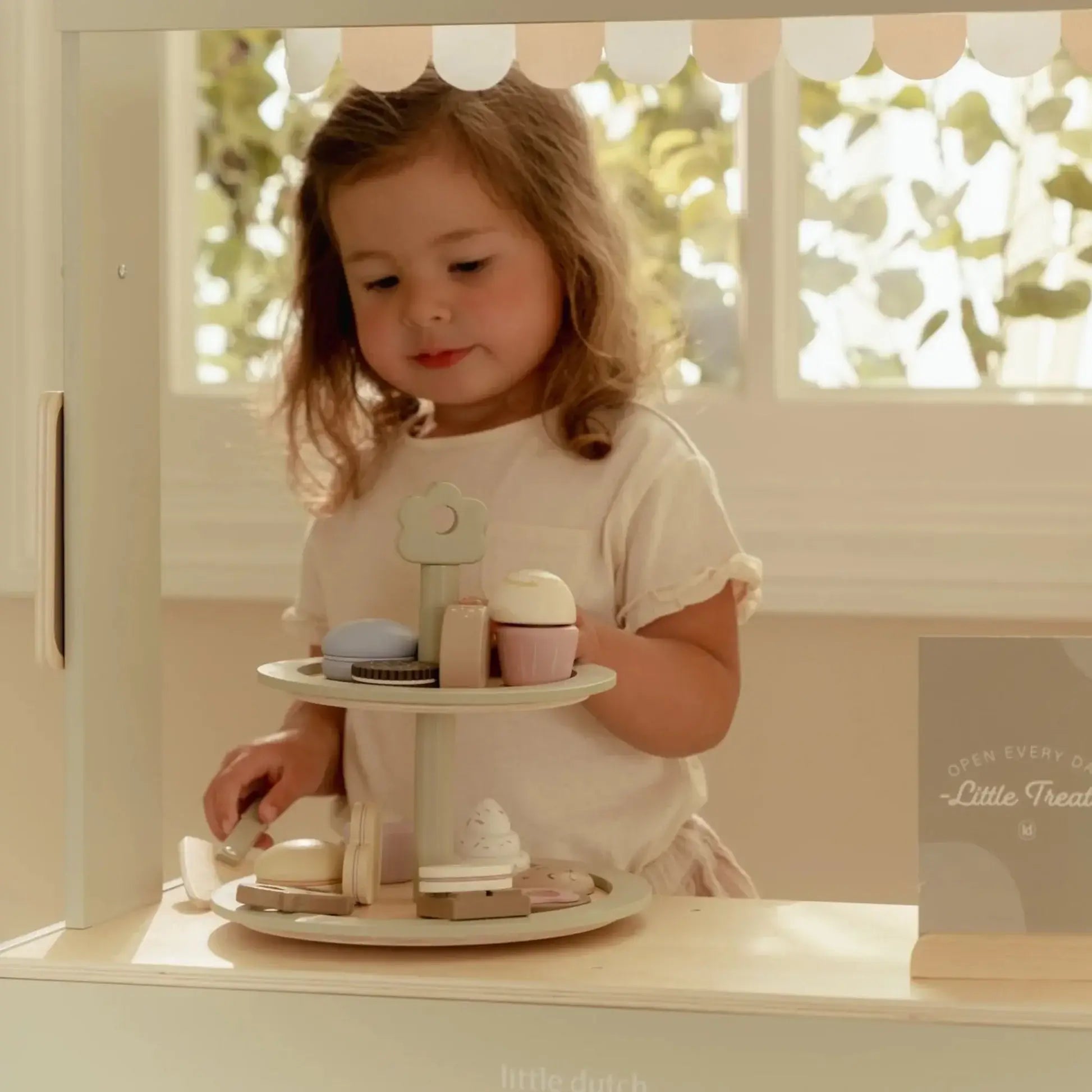 Bandeja de Bolos Little Dutch com criança organizando doces em um cenário de chá imaginativo.