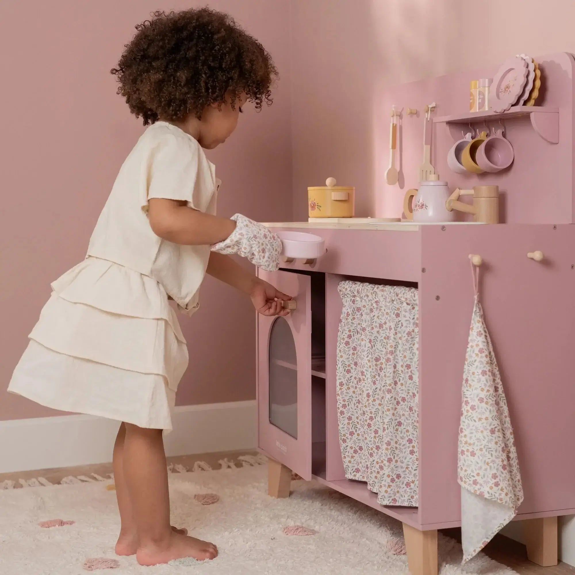 Criança brincando na Cozinha Rosa - Little Dutch, um modelo encantador em madeira com elementos de Soft Flowers.