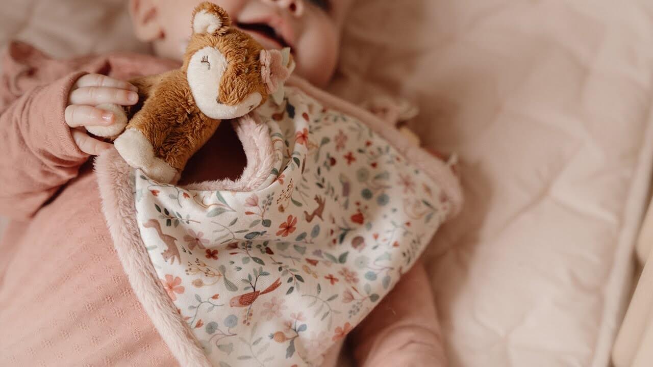 Baby holding Doudou macio Corça from Little Dutch, featuring floral design and plush deer for comfort.