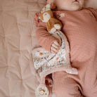 Baby sleeping with soft doudou macio Corça from Little Dutch in floral design, providing comfort and sensory exploration.