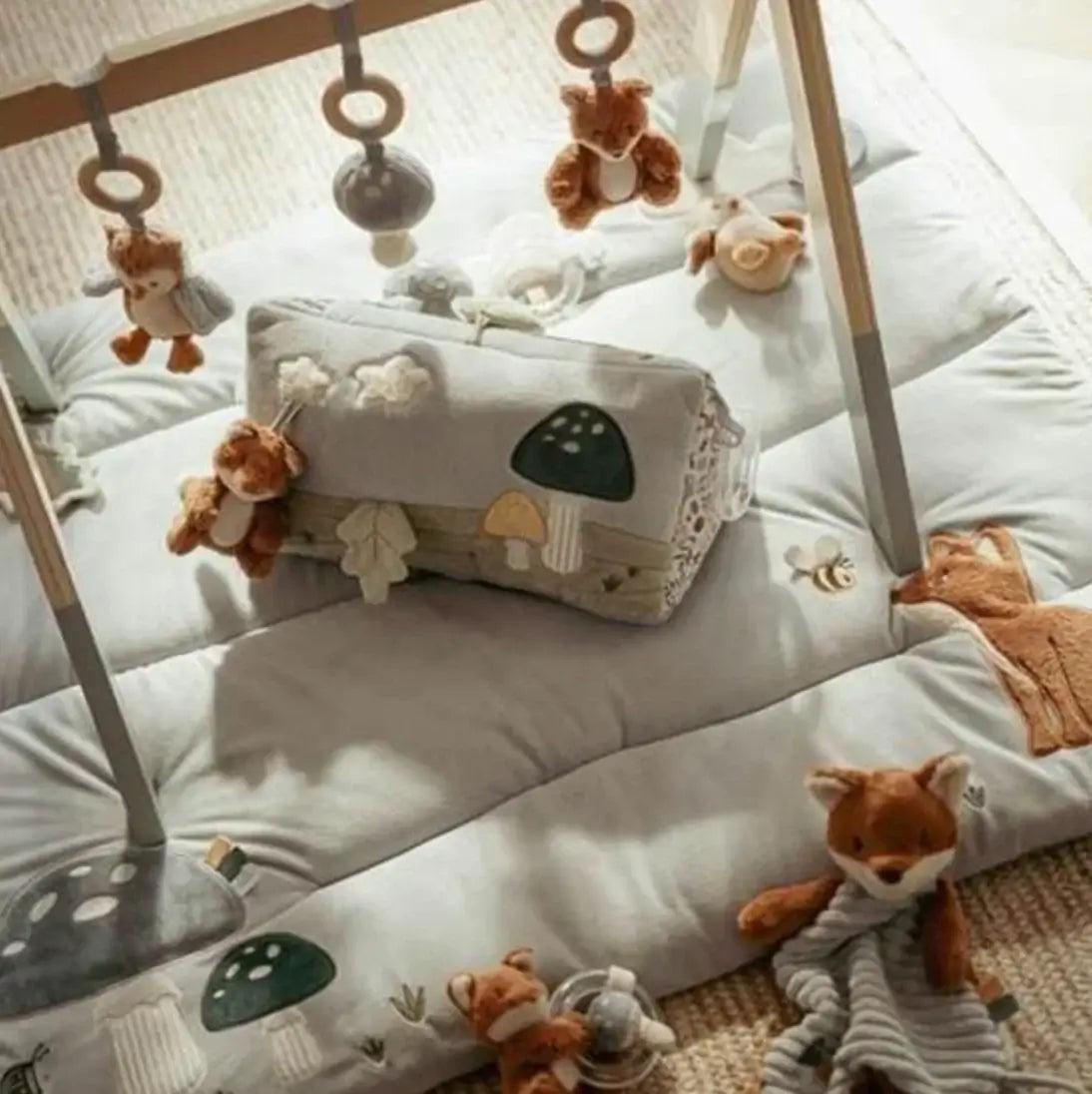 Soft play mat with forest-themed toys and adorable plush animals for baby comfort and playtime.