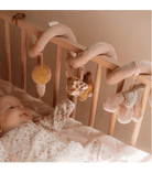 Baby exploring the Little Dutch Fairy Garden activity spiral in a crib, featuring soft toys and vibrant colors.