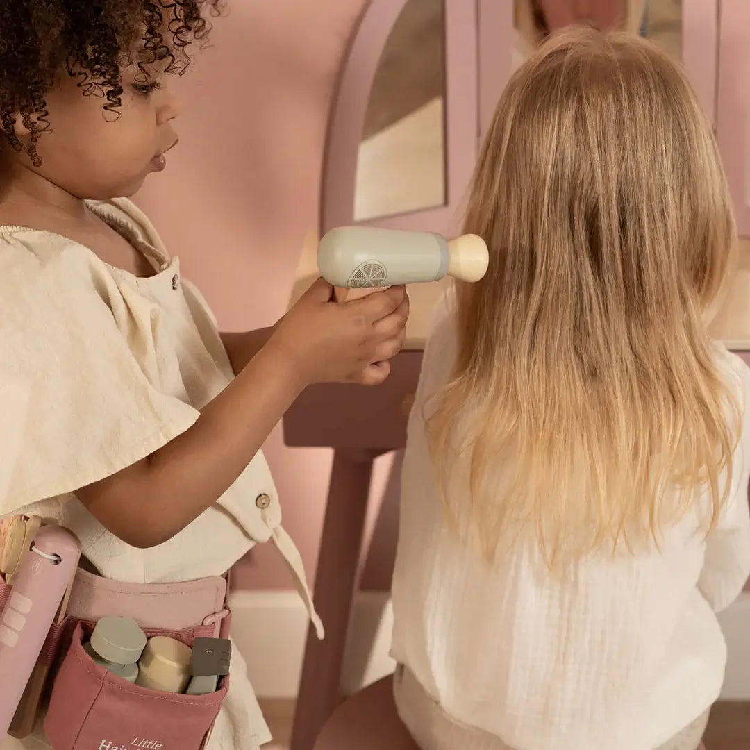 Criança usando o secador do Conjunto de Cabeleireiro Little Dutch em um salão de beleza de brinquedo.