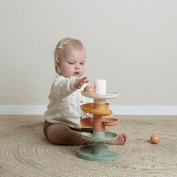 Baby playing with Little Dutch Torre Espiral de Bolas, colorful stacking toy promoting learning and motor skills.